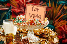 Food And A Note For Santa On A Table Ornamented With Golden Tinsel