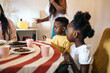 © Pedro Merino/Stocksy - Little children sitting at the table at a family celebration