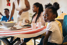 Little Black Girl Making Funny Faces At A Family Celebration