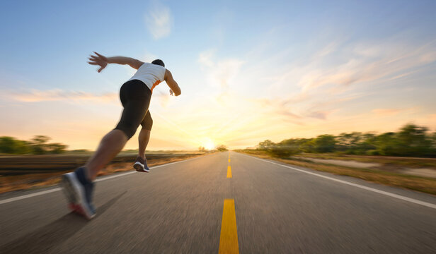 action motion blur of a man running on country road with sunrise background...
