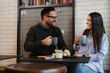 © zorandim75 - Couple having coffee at a coffee shop. Man and woman meeting at cafe.