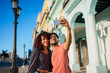 © Daniel Gonzalez/Stocksy - Cuban couple taking selfie on street
