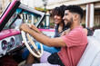 © Daniel Gonzalez/Stocksy - Cheerful Cuban couple driving in retro cabriolet car