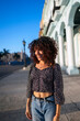 © Daniel Gonzalez/Stocksy - Happy Cuban woman on city street