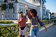 © Daniel Gonzalez/Stocksy - Happy Cuban couple raising arms and smiling