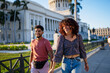 © Daniel Gonzalez/Stocksy - Merry Cuban couple strolling on street during date