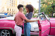 © Daniel Gonzalez/Stocksy - Romantic couple near pink old timer in city