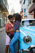 © Daniel Gonzalez/Stocksy - Romantic Cuban couple with phone near vintage car
