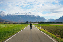 Man Riding Bicycle In Countryside In Alps