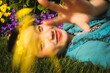 © Angela Kong/Stocksy - Woman lying in grass with flowers