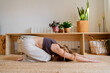 © Eloisa Ramos/Stocksy - Fitness woman doing yoga at living room