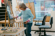 © Jimena Roquero/Stocksy - Woman painting with pastel technique in art school studio
