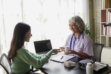 Wall Mural -  consulting female patient about pills and discussing health treatment sitting in the office at the desk. Medicine and health care concept. Doctor prescribing medicine to patient in the office.