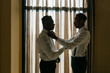 © Ezequiel Giménez/Stocksy - Black groom and best man near window