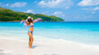 Young Asian woman with a hat at a white tropical beach Anse Lazio beach Praslin Tropical Seychelles Islands. 