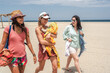 © Luis Herrera/Stocksy - group of friends walking on the beach