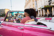 © Daniel Gonzalez/Stocksy - Cuban couple driving retro car in city