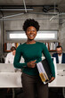 © Aleksandra Jankovic/Stocksy - Smiling Businesswoman Holding Files In The Office