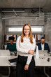 © Aleksandra Jankovic/Stocksy - Portrait Of A Smiling Redhead Businesswoman In The Office