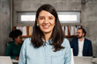 © Aleksandra Jankovic/Stocksy - Close Up Portrait Of A Smiling Brunette Woman At The Workplace