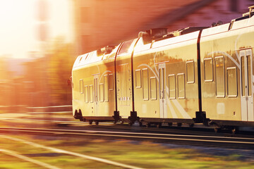 Wall Mural - passenger train moving along railway in sunset in summer.