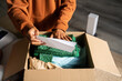 © Alba Vitta/Stocksy - Man opening delivery box from second hand shop