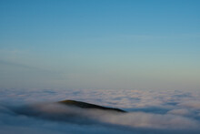 A Hill Poking Above The Clouds