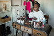 © Lupe Rodríguez/Stocksy - black woman doing makeup at home