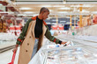 © Ivan Gener/Stocksy - Woman choosing frozen food in a market