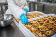© Daniel Gonzalez/Stocksy - Crop worker adding ingredients to canned mussels