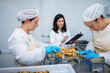 © Daniel Gonzalez/Stocksy - Employees of factory canning seafood product