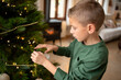 © Albert Martinez/Stocksy - Boy decorating Christmas tree