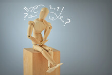 Wooden Mannequin In Thinking Pose On Wooden Block - Concept Of Thinking And Indecision