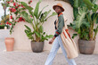 © Ivan Gener/Stocksy - Stylish woman walking by plants outdoors