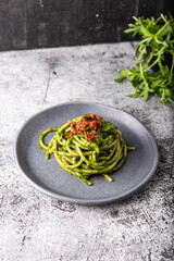 Wall Mural - Gragnano spaghetti with homemade rocket pesto and dried tomatoes. Dish suitable for adults and children, healthy and tasty.