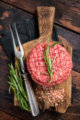 Wall Mural - Raw minced homemade farmers grill beef burgers on chopping board with salt and rosemary. Wooden background. Top view