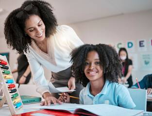 Young child learning maths, happy teacher in classroom with children and knowledge at desk. Female educator writing in workbook, reading kids notebook at school and teaching student with assignment