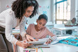 © Lumeez/peopleimages.com - Female teacher helping young girl, teaching creative work in book and children in sunny classroom. Education empowerment in school, educator speaking to student and learning mathematics at desk