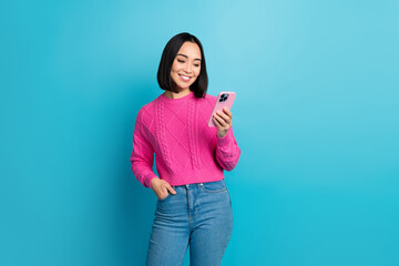 Poster - Portrait of gorgeous positive thai person use telephone write typing isolated on blue color background