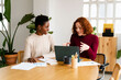 © Nuria Seguí/Stocksy - Smiling Women Coworkers Working Together In Modern Workspace