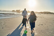 © Caia Image - Brother and sister playing with soccer ball on sunny beach