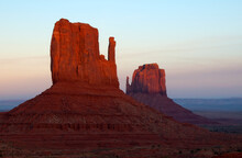 The Famous Mittens Are Illuminated At Dusk In Monument Valley, AZ.