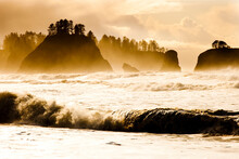 Massive Waves Crash Into The Shore Of Rialto Beach From A Passing Storm. Sea Stacks With Trees Growing On Top Can Be Seen In The Distance.