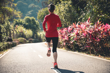 Wall Mural - Fitness woman runner running on winter park trail