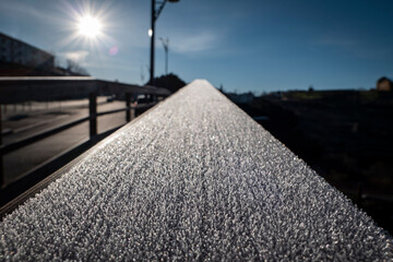 Formação de geada sobre um corrimão de madeira num dia frio de inverno