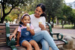 © Nina/peopleimages.com - Black family, park and ice cream with a mother and daughter bonding together while sitting on a bench outdoor in nature. Summer, children and garden with a woman and girl enjoying a sweet snack