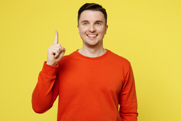 Wall Mural - Young smiling cheerful excited caucasian man wear orange casual clothes holding index finger up with great new idea isolated on plain yellow color background studio portrait. People lifestyle concept.