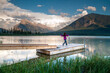 © Cavan Images - Young girl runs along wharf at mountain lake