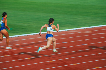 Wall Mural - A lone sprinter captured in motion on the athletics track in rainy weather, showcasing determination and focus. Suitable for sports and fitness campaigns