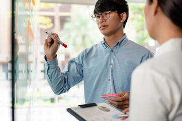 Poster - Two business executive team holding and taking notes keyword on board wall to brainstorm about a new business project for planning marketing plan together in the office